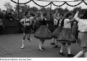 Tanzende Paare in Tracht bei einer Freiluft-Kulturveranstaltung