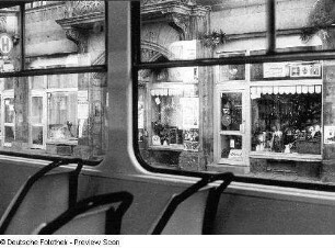 Dresden-Neustadt, Königsbrücker Straße. An einer Haltestelle. Blick auf Schaufenster, fotografiert aus einer Straßenbahn