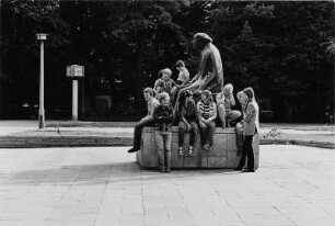 Denkmal für Käthe Kollwitz : Berlin-Prenzlauer Berg, Kollwitzplatz. Kinder und Jugendliche auf dem Sockel des Denkmals für die Bildhauerin Käthe Kollwitz (1958; G. Seitz)