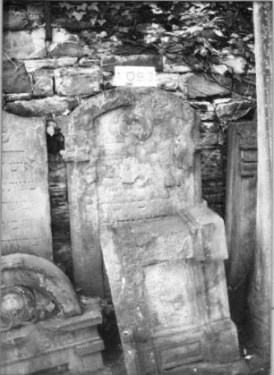 Grabstein 1093 (Index: 99630596) Material: Sandstein Zustand: stark verwittert Maße HxBxT: 135x80x9 cm Beschreibung: Stele mit Segmentbogenabschluß Symbolik: verwitterter Kranz: Grabstein 1093