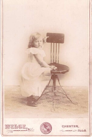 Foto Mädchen im Fotoatelier lehnt an einem Stuhl