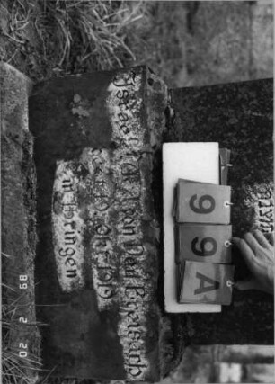 Grabstein 99 (Index: 99798523) Material: Sandstein Zustand: leicht verwittert/Aufsatz fehlt Maße HxBxT: 116x56x48 cm Beschreibung: würfelförmige Stele mit Aufsatz, Sockel: Grabstein 99A
