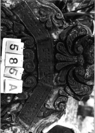 Grabstein 585 (Index: 99753080) Material: Sandstein Zustand: leicht verwittert Maße HxBxT: 160x101x18 cm Beschreibung: Stele, geschwungen eingezog. Rundbogenabschl. , Schriftfeld eingetieft Symbolik: Pinienzapfen, Ranken, Muscheln, Voluten, Schriftband Besonderheit: Zitat angelehnt an Deuteronomium 34, 5: Grabstein 585A