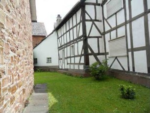 Kirchhof im Norden nach Westen mit Kirchhofmauerbasis und angrenzenden Fachwerkhäusern