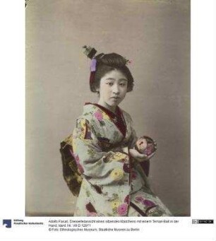 Dreiviertelansicht eines sitzenden Mädchens mit einem Temari-Ball in der Hand