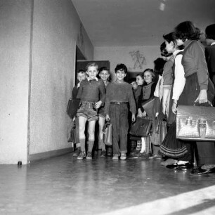 Schichtenunterricht an einer Schule. Während eine Schulklasse den Unterrichtsraum verläßt, wartet die nächste Klasse schon auf dem Flur