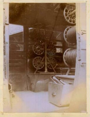 Foto des Innenraums eines als Bauwagen genutzten Omnibusses der Firma Saurer mit Kabeltrommeln und in Kästen untergebrachtem Vorratsmaterial