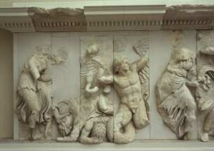 Pergamonaltar, Nordfries - Ausschnitt: Aphrodite zieht eine Lanze aus einem getöteten Gegner; in der Mitte ein geflügelter Gigant, der von Eros attakiert wird; rechts die Göttin Dione