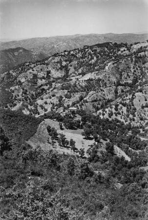 Landschaftsblick : Blick auf Berghang und Tal unterhalb des Dorfes Aït Aïssa Mimoune. Im Tal befinden sich Getreidefelder.