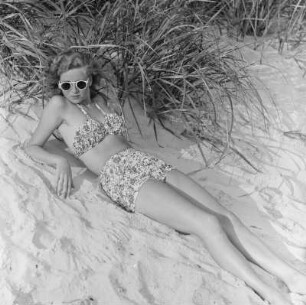 Frau im Bikini mit Sonnenbrille am Strand
