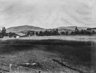 Farm : Blick über ein Farmgelände mit landwirtschaftlichen Nutzflächen, im Hintergrund weitere Gehöfte