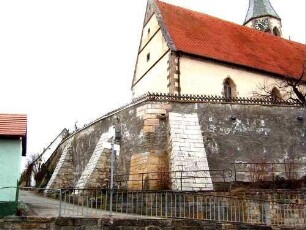 Ansicht von Südwesten mit Kirche über Kirchhofmauer (Wehrgang mit Steinbrüstung und Schießscharten abgetragen - Strebepfeiler im Westen und Südwesten)