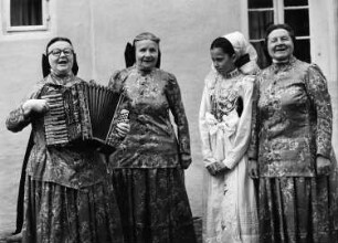 Crostwitz. Drei Frauen (eine mit Akkordeon) und ein junges Mädchen in sorbischer Tracht