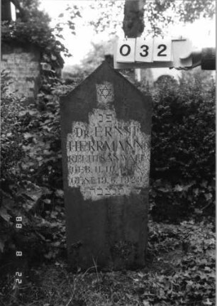Grabstein 32 (Index: 100080088) Material: Kunststein? Zustand: gut Maße HxBxT: 102x42x20 cm Beschreibung: sich nach oben verbreiternde Stele, eingezogener giebelartiger Abschluß Symbolik: Davidstern: Grabstein 32
