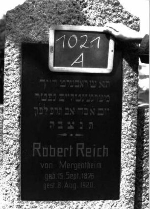 Grabstein 1021 (Index: 100104007) Material: Granit Zustand: gut erhalten Maße HxBxT: 193x83x25 cm Beschreibung: Stele auf getrepptem Sockel, Konvexbogenabschluss, halbhohe Seitenwangen, eingelassene hochrechteckige Schrifttafel: Grabstein 1021A