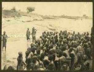Gruppe afrikanischer Arbeiter an einem flachen Gewässer