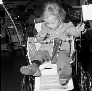 Kleinkind in einem Kindersportwagen. Aufnahme in einem Fachgeschäft für Kinderwagen
