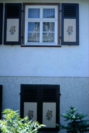 Teilansicht eines Hauses mit bemalten Fensterläden