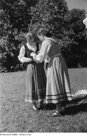 Junge Frauen sich beim Ankleiden der Kostüme helfend