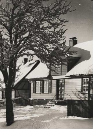 Winter. Tief verschneite Häuser und Bäume in einem Dorf
