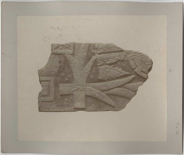 Fragment d'une plaque de pierre, avec le relief d'une boule d'herbe (cacatapayolli), de deux pointes de feuilles d'argaves (uitztli) et d'une tonnelle de roseaux.