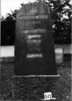 Grabstein 50 (Index: 99804537) Material: Granit Zustand: teilweise abgeblättert Maße HxBxT: 170x70x30 cm Beschreibung: Stele mit unregelmäßigem Rand, Sockel, Rundbogenabschluß Besonderheit: Doppelgrab für Eheleute: Grabstein 50