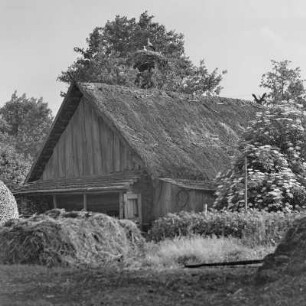 Blick auf ein mit Strohgedecktes Blockhaus mit Storchennest. : Wid na ze słomu pokrytu kładźitu chěžu z baćonjacym hnězdom.