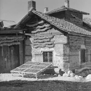Alltagsbild. Frauen unterwegs in Bansko. Gestelle für das Trocknen der Tabakblätter am Wohnhaus in Bansko