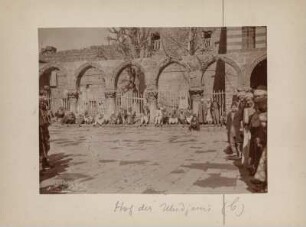 Hof der Ulu Cami : Der Innenhof der Ulu Cami (Große Moschee). Zahlreiche Männer sitzen an einem Zaun, rechts und links stehem Männer.