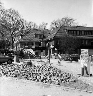 A 1: Raststätte "Trave" bei Reinfeld: Modernisierung: Pflasterung des Außengeländes, Pflastersteine, Betonplatten, Warnbaken: parkendes Auto: hinten Gaststättengebäude, Personen auf Treppe: vorne rechts Hinweisschild "Unser Küchenchef empfiehlt"
