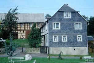 Blick in einen Bauernhof mit großer Scheune, Obstbäumen im Hof
