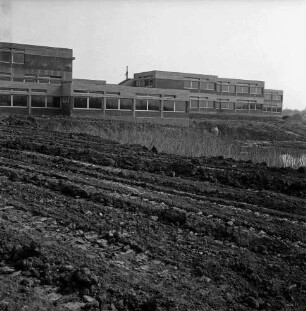 Grund- und Hauptschule am Masurenweg: Masurenweg: Neubau: Schulgebäude vor Fertigstellung: vorn unbefestigtes Gelände mit Wassertümpel: 24. März 1973