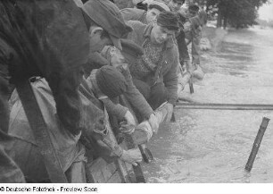 Männer bei Schutzvorkehrungen (Stabilisieren eines Dammes)