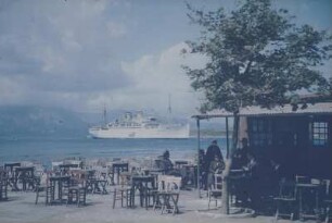 Reisefotos Griechenland. Strandcafé und vor der Küste ankerndes Passagierschiff "Milwaukee" (vielleicht im Mittelmeer)