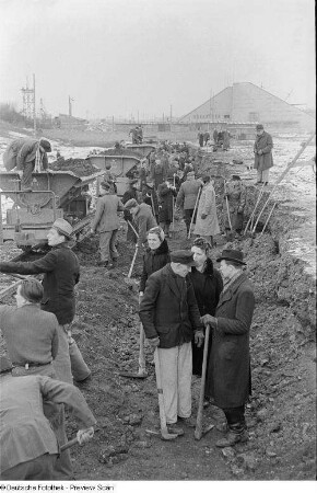 Angestellte der Stadtverwaltung beim Entladen eines Kipplorenzugs