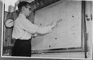 Vergleichsabbildungen. Mann auf einer Landkarte (Signivikanzniveau Radio-Karte von 1933) Einzeichnungen vornehmend, wahrscheinlich auf dem Flughafen von Amsterdam