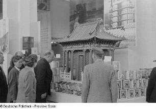 Besucher vor einem Messestand mit chinesischen Lackfarben