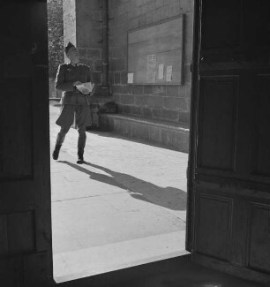 Blick durch die Tür des Westportals von Notre-Dame-de-la-Couture in Le Mans auf den das Portal betrachtenden Hans-Adalbert von Stockhausen (Aufnahme im Rahmen der Fotokampagne im besetzten Frankreich)