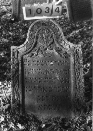Grabstein 1034 (Index: 99751270) Material: Sandstein Zustand: gut Maße HxBxT: 101x64x9 cm Beschreibung: Stele, Konvexbogenabschluß, Schriftfeld eingetieft Symbolik: Muschel, Blumen, Ranken, Scheiben: Grabstein 1034