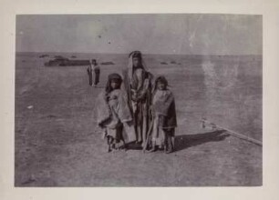 Kurdische Frau mit Kindern : Frau der Kurden mit zwei Kindern. Im Hintergrund ein Mann und Zelte in der mesopotamischen Steppe.