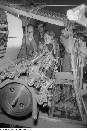 Besucher am Stand der VVB Polygraph während der Vorführung einer papierherstellenden Maschine, Internationale Ausstellung für Buchgewerbe und Graphik (Bugra) 1953