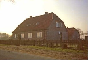ehemaliges Gut Trenthorst-Wulmenau: Wulmenau 30: Landarbeiterhaus: traufständiges Doppelwohnhaus: an Giebelseite Eingangstür: dahinter Stallgebäude