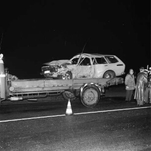 B 404: bei Wolkenwehe: Verkehrsunfall: Auffahrunfall und Zusammenstoß von drei Pkws: Unfallfahrzeug mit eingedrückter Karosserie auf Ladefläche von Abschleppwagen: rechts Abschlepper mit Arbeitshandschuhen, Mann, zwei Polizisten mit Markierungsrad: auf Fahrbahnmarkierung Leitkegel: im Dunkeln