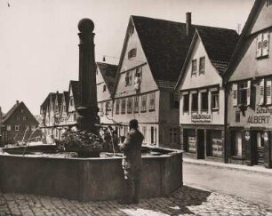 Baden-Würtemberg. Schillerstadt Marbach am Neckar. Ansicht einer Straße mit Fachwerkhäusern. Ein Mann steht an einem Brunnen.