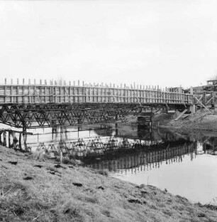 Trave: Spannbetonbrücke: Neubau: Gerüst aus Stahlträgern über Fluss: darauf Holzverschalung für Betonteile