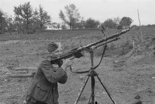Zweiter Weltkrieg. Kampfpausen. Wehrmachtsangehöriger an einem Maschinengewehr