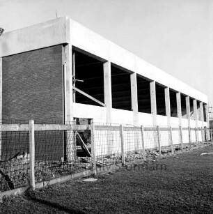 Sporthalle: Realschule [später Dietrich-Bonhoeffer-Realschule]: Am Schulzentrum: in Bau: Rohbau: Außenansicht: Längsseite Verblendung mit Waschbetonplatten: Stirnseite Verkleidung mit Vormauersteinen: Bauzaun