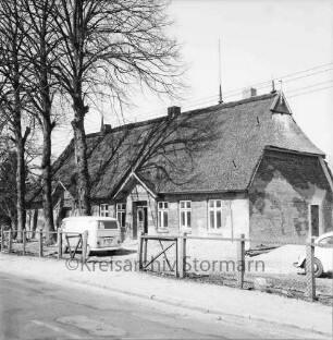 Oetjendorfer Landstraße: Wohnhaus mit Reetdach: ehemaliges Schulgebäude: links Baumreihe: daneben Lieferwagen: rechts VW-Käfer: vorn Zaun