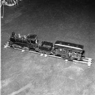 Dampflokomotive einer Modelleisenbahn mit Schlepptender und Personenwagen, aufgenommen in einem Modelleisenbahnmuseum