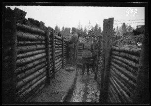 Komaika-Stellung (=Kamaja/Kamoja, Gewässer in Litauen): 2 Offiziere und ein Soldat in einem mit Holzstämmen befestigten Laufgraben ("Stellungsausbau")